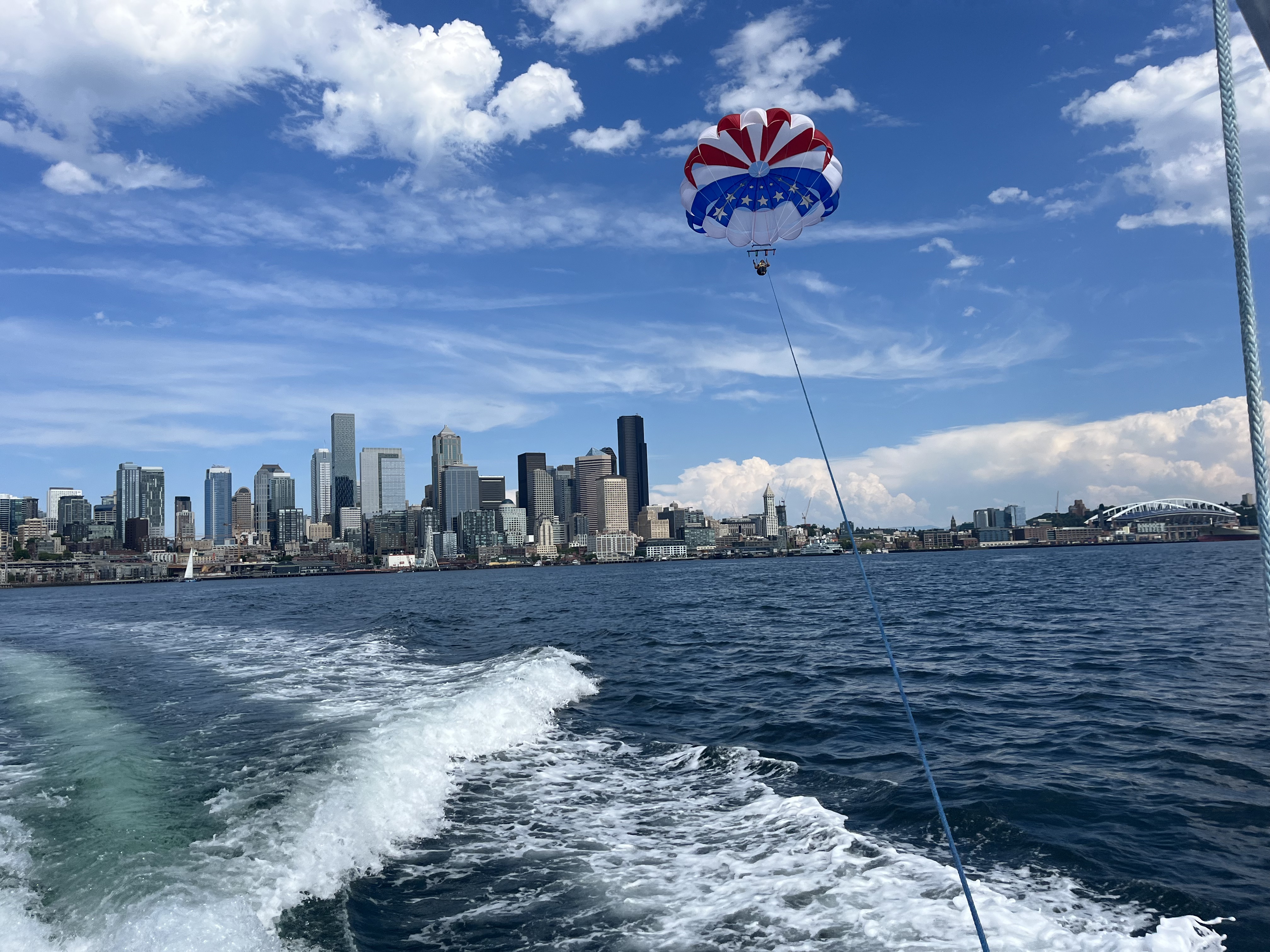 Solo parasailer with flag chute above the Seattle skyline